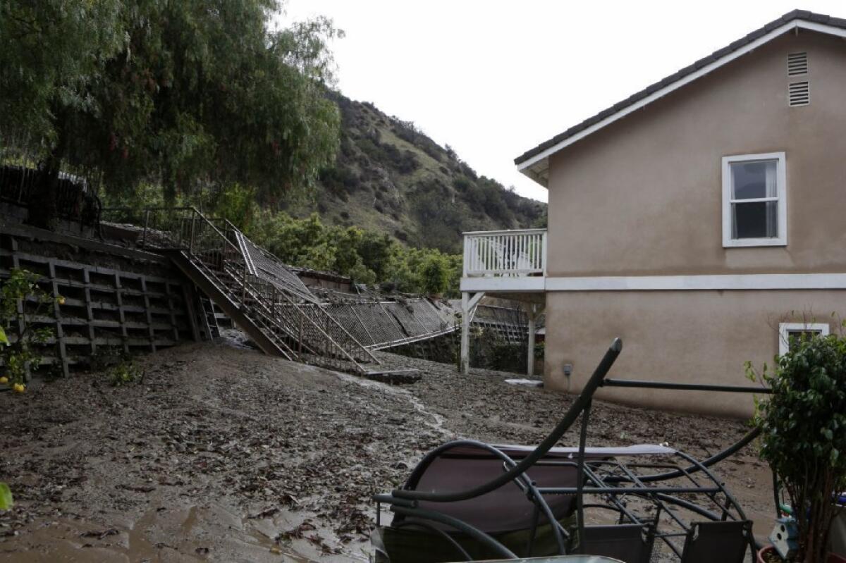 Mud oozes into the backyard of a home along Ridge View Drive in Azusa early Saturday.