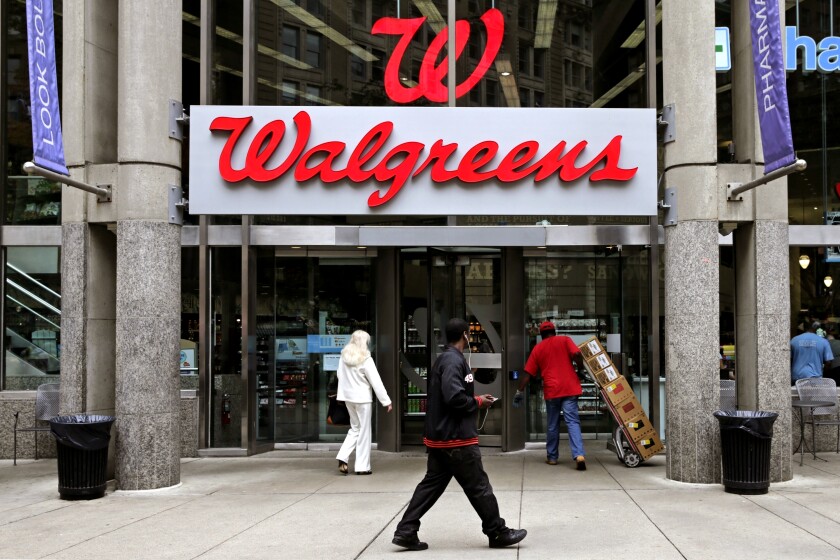 FILE - In this June 4, 2014, file photo, people walk in to a Walgreens retail store in Boston. Walgreens slashed its 2019 forecast and missed second-quarter expectations with a performance that sent its shares plunging Tuesday, April 2, 2019 and knocked down the Dow Jones industrial average. The nation’s largest drugstore chain said it now expects adjusted earnings per share to be roughly flat this year after confirming as recently as late December a forecast for growth of 7% to 12%. (AP Photo/Charles Krupa, File)