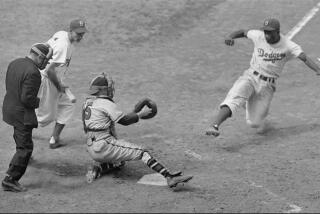 FILE –– Brooklyn Dodgers Jackie Robinson, steals home plate as Boston Braves' catcher Bill Salkeld is thrown off–balance on pitcher Bill Voiselle's throw to the plate during the fifth inning at Ebbets Field in New York August 22, 1948. The umpire is Jocko Conlan. (AP Photo/File)