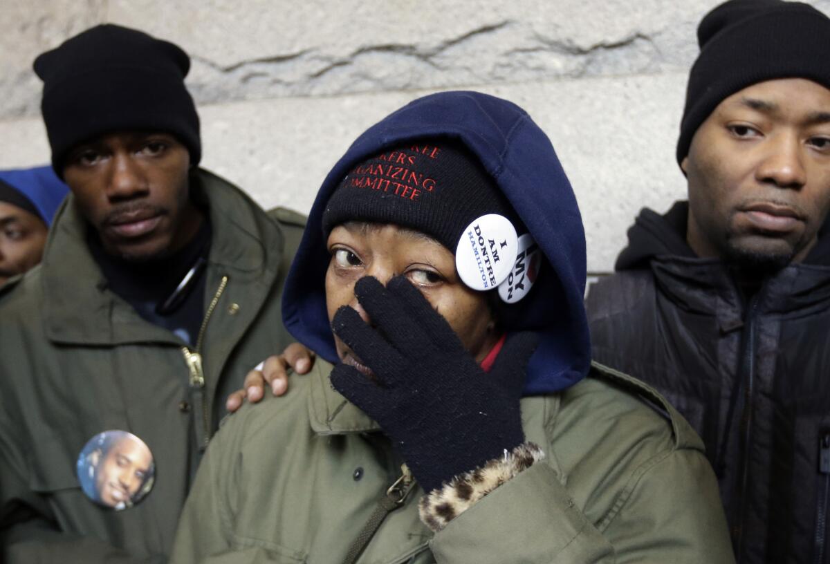 Dontre Hamilton's mother, Maria Hamilton, wipes her eyes as she is is flanked by her sons Dameion Perkins, right, and Nate Hamilton on the steps on the federal courthouse in December 2014 in Milwaukee. (Morry Gash / Associated Press)