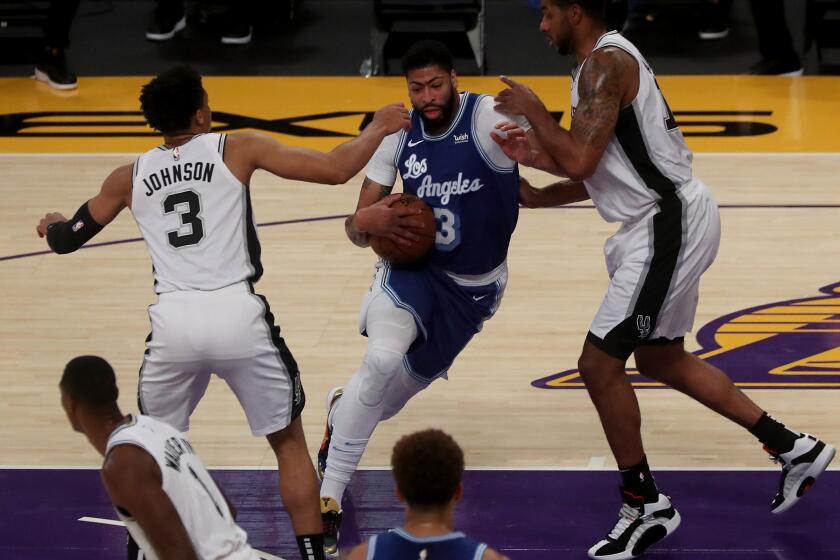 LOS ANGELES, CA. - JAN. 7, 2021. Lakers big man Anthony Davis splits the defense of the Spurs in the first quarter on Thursday night, Jan. 7, 2021, at Staples Center in Los Angeles. (Luis Sinco/Los Angeles Times)