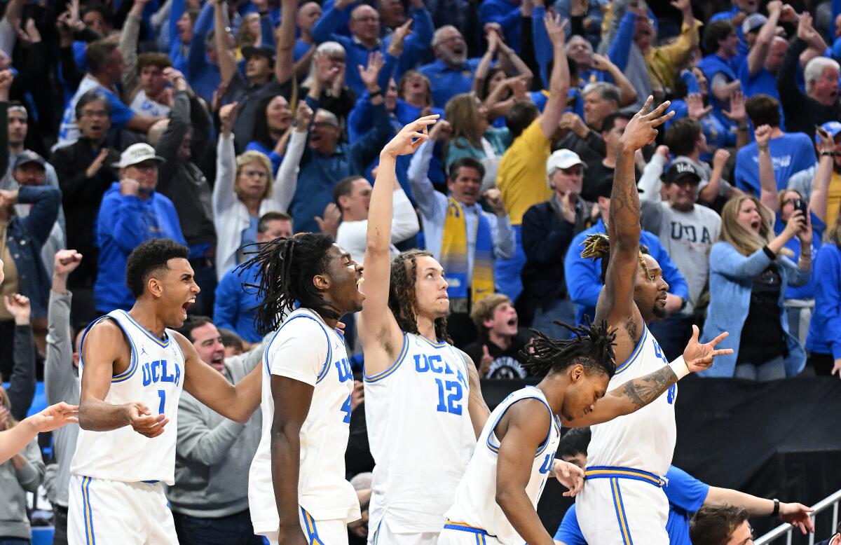 The UCLA bench celebrates a three-pointer during a win over Northwestern in the second round of the NCAA tournament.