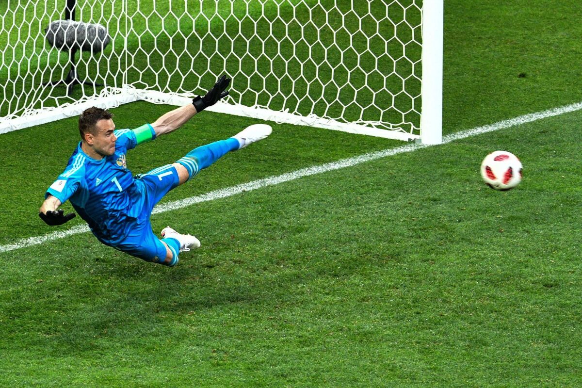 Russia goalkeeper Igor Akinfeev dives to his right but was able to make a kick save to win the game.