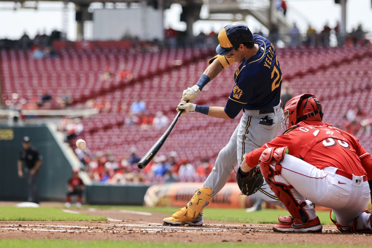 Milwaukee Brewers' Christian Yelich hits a ground-rule double during the first inning of a baseball game against the Cincinnati Reds in Cincinnati, Wednesday, May 11, 2022. (AP Photo/Aaron Doster)