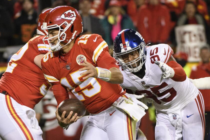 New York Giants linebacker Quincy Roche (95) chases Kansas City Chiefs quarterback Patrick Mahomes (15) during the first half of an NFL football game, Monday, Nov. 1, 2021 in Kansas City, Mo. (AP Photo/Reed Hoffmann)