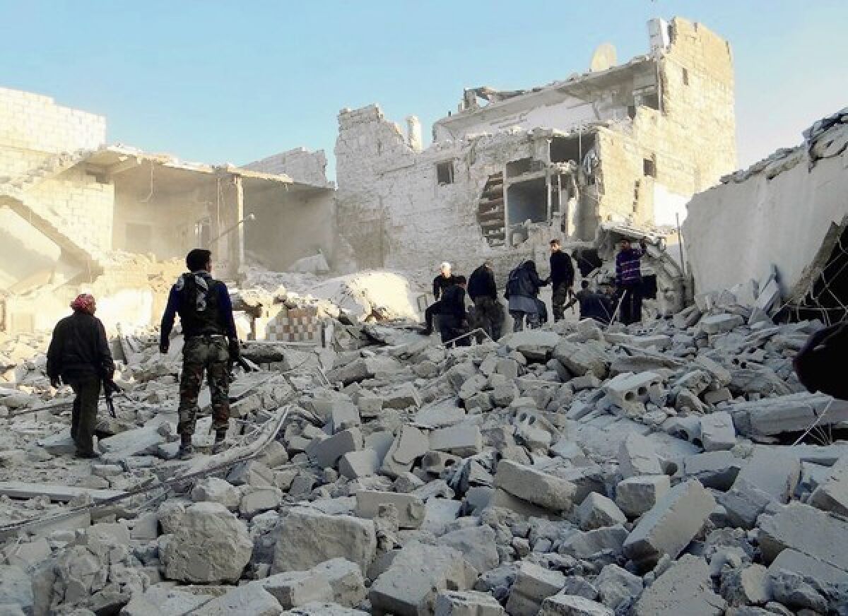 Syrian rebels stand in the rubble of buildings after reported government airstrikes near Aleppo's international airport.