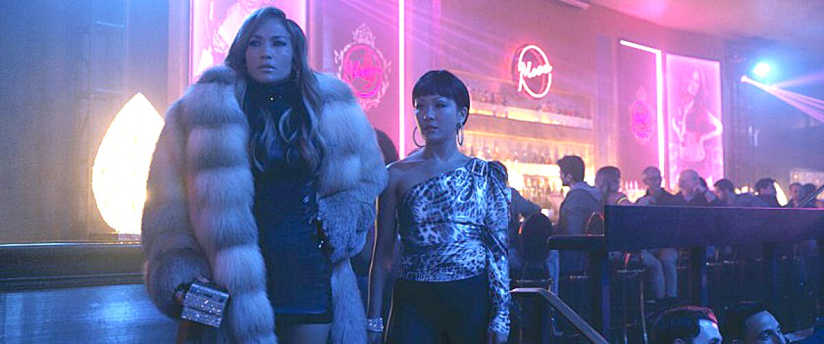 Jennifer Lopez, left in a fur coat, and Constance Wu in "Hustlers."