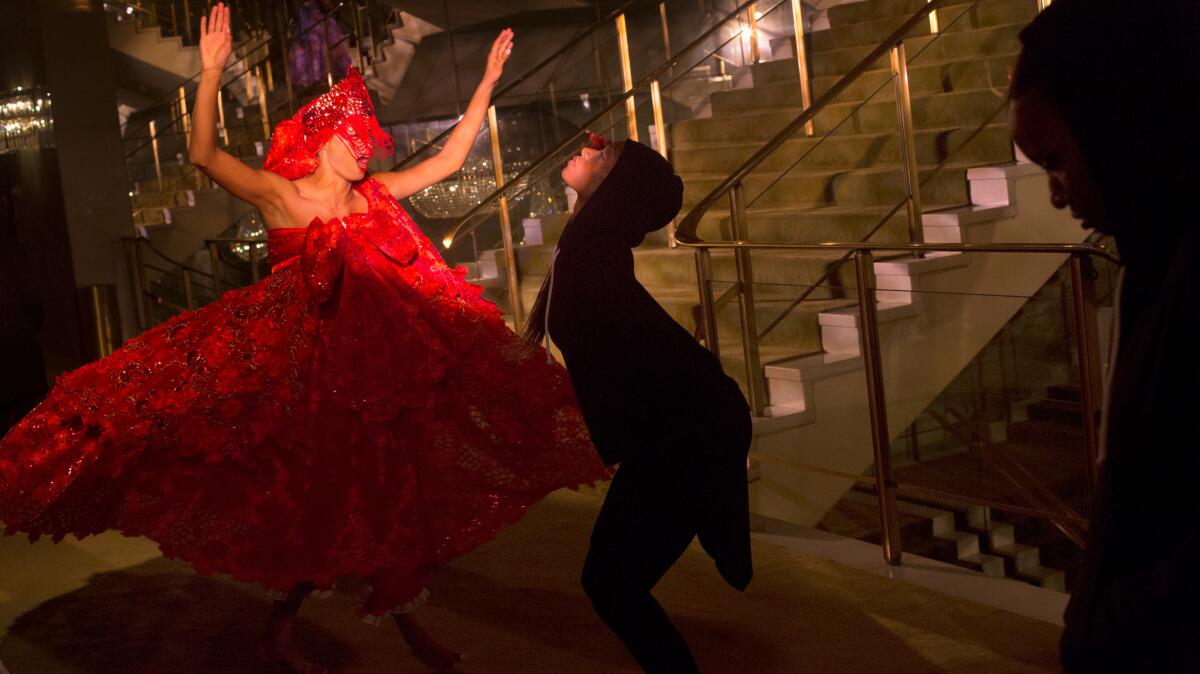 Clad in red, Rachel Hernandez dances as part of the Viver Brasil Dance Company's staging of "Revealed" on the staircase of the Dorthy Chandler Pavilion.
