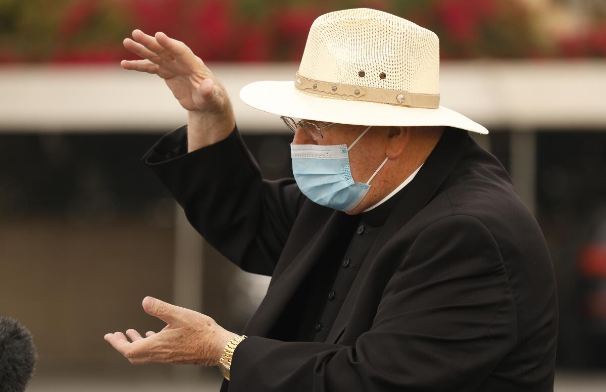 A masked priest gestures
