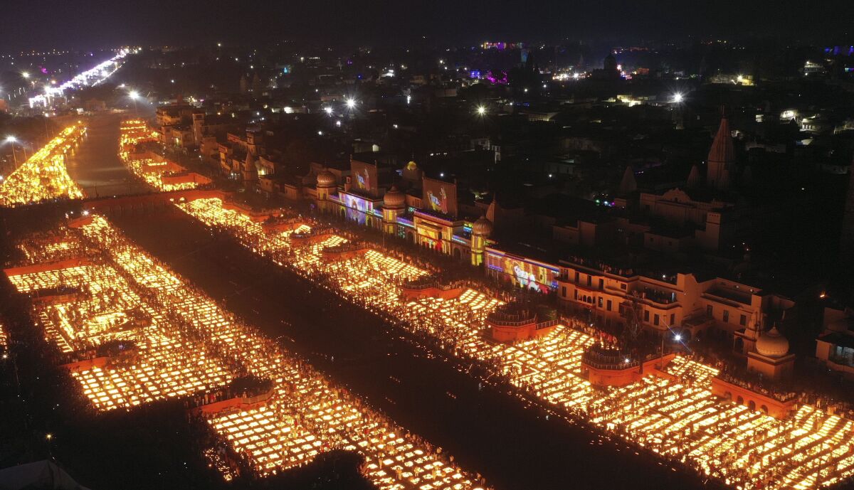 People light lamps on the banks of the river Saryu in Ayodhya, India, Wednesday, Nov. 3, 2021. Over 900,000 earthen lamps were lit and were kept burning for 45 minutes as the north Indian city of Ayodhya retained its Guinness World Record for lighting oil lamps as part of the Diwali celebration – the Hindu festival of lights. (AP Photo/Rajesh Kumar Singh)