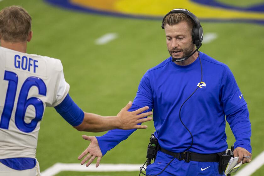 Rams head coach Sean McVay low fives quarterback Jared Goff.