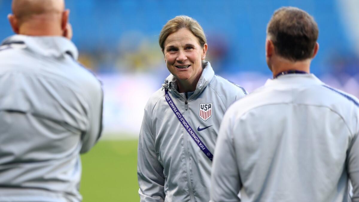 USWNT coach Jill Ellis talks to members of her staff before a group game against Sweden.