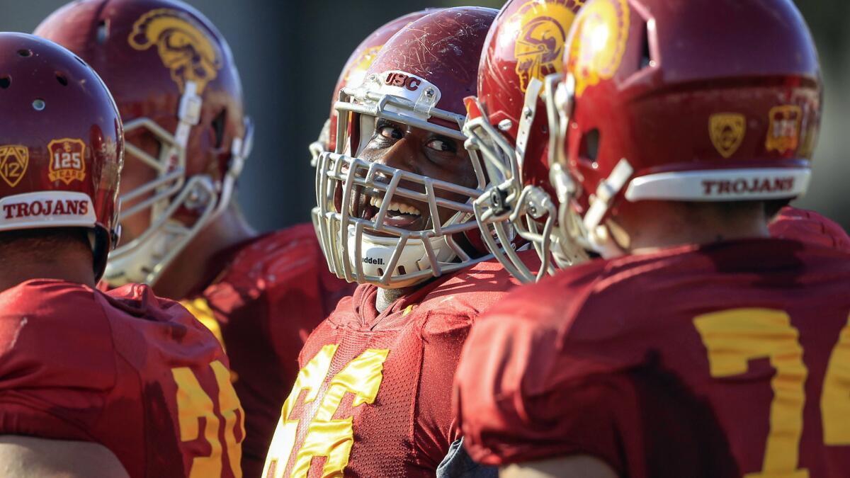 Former USC center Marcus Martin, center, smiles during a team practice session in October 2013.