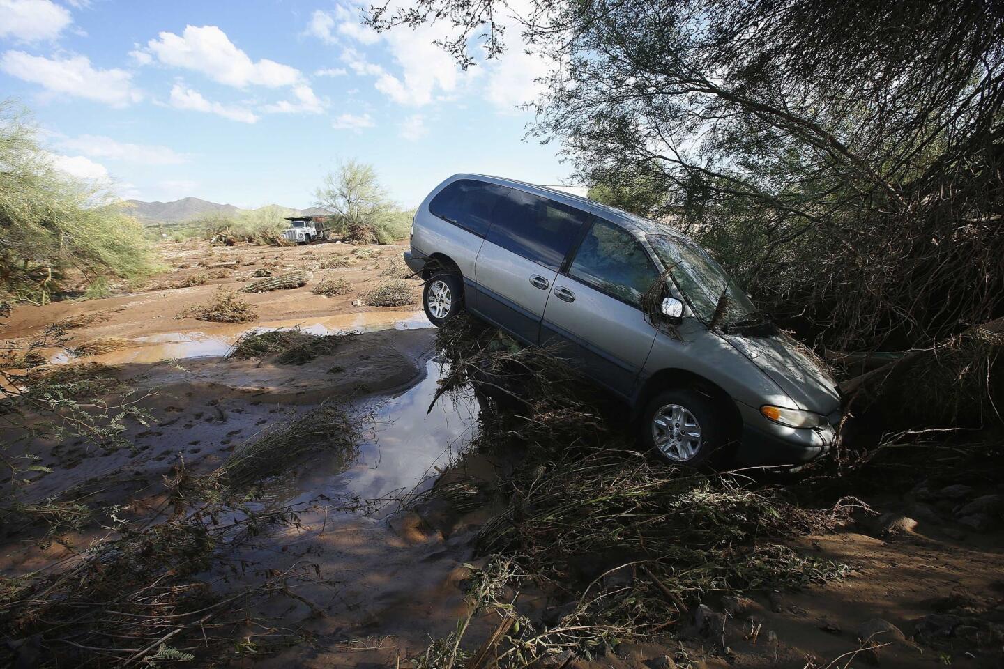 Flash flooding pushed a vehicle onto debris when rising waters overran Skunk Creek on Aug. 19 in New River, Ariz.