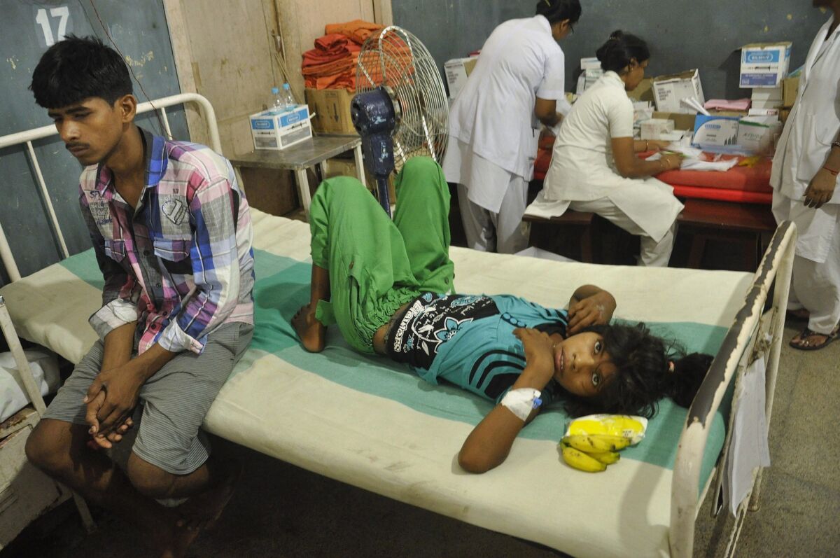 An Indian schoolgirl recovering from food poisoning rests at the Patna Medical College and Hospital.