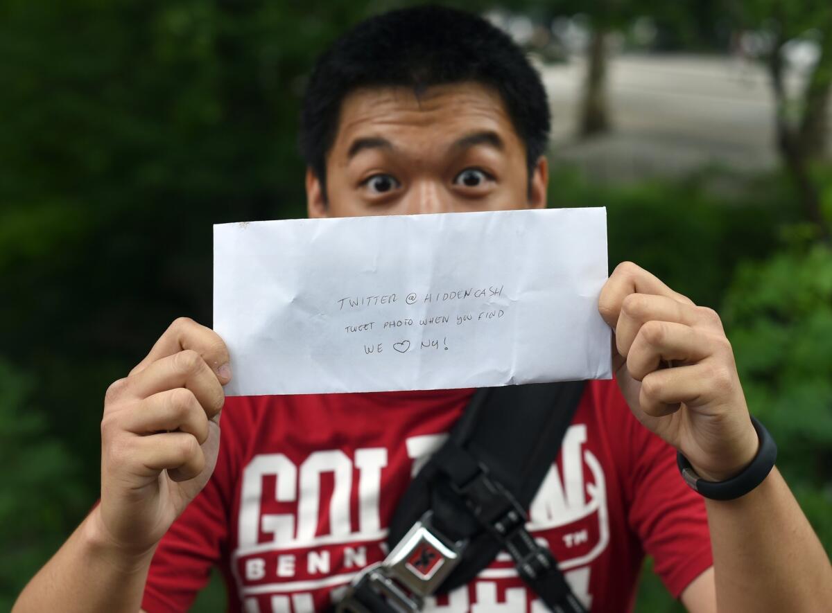 Kurt Dee holds an envelope with money that he found in New York's Central Park as part of a @HiddenCash scavenger hunt in June.