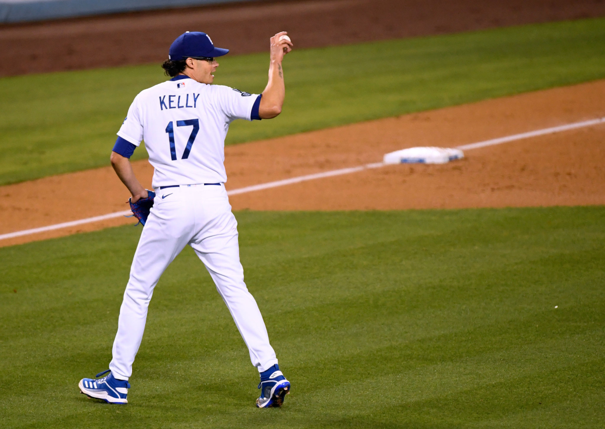 Dodgers reliever Joe Kelly throws the ball back to manager Dave Robert after leaving the game.