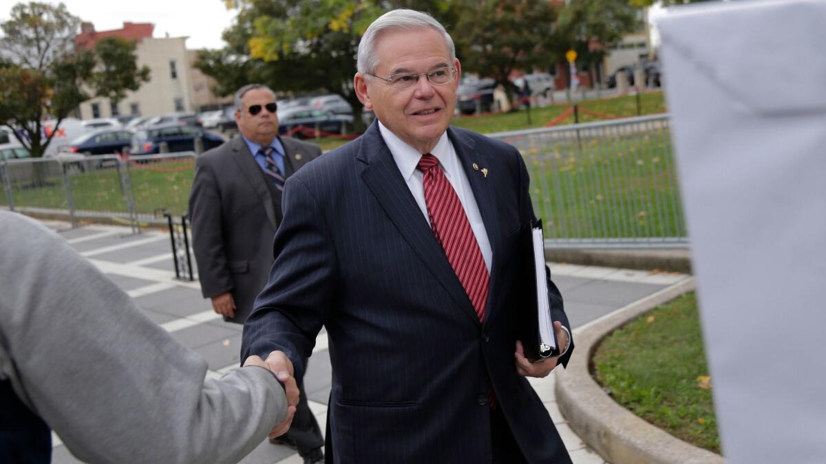 Senator Robert Menendez greets supporters as he arrives to court in Newark, N.J. on Oct. 16, 2017.