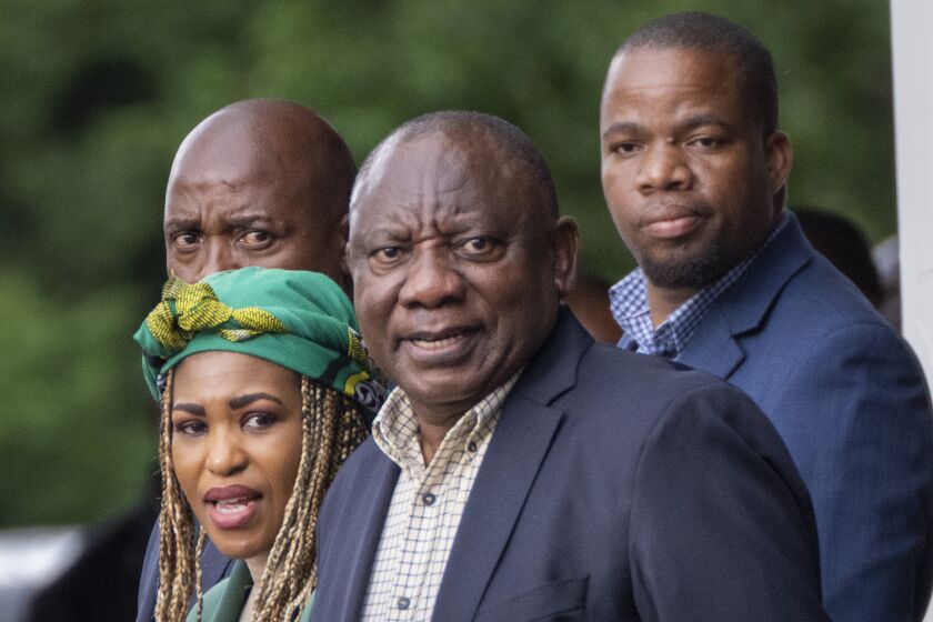 South African President Cyril Ramaphosa, center, leaves an African National Congress (ANC) national executive committee meeting in Johannesburg, South Africa, Monday Dec. 5, 2022. Ramaphosa might lose his job, and his reputation as a corruption fighter, as he faces possible impeachment over claims that he tried to cover up the theft of millions of dollars stashed inside a couch on his farm. (AP Photo/Jerome Delay)