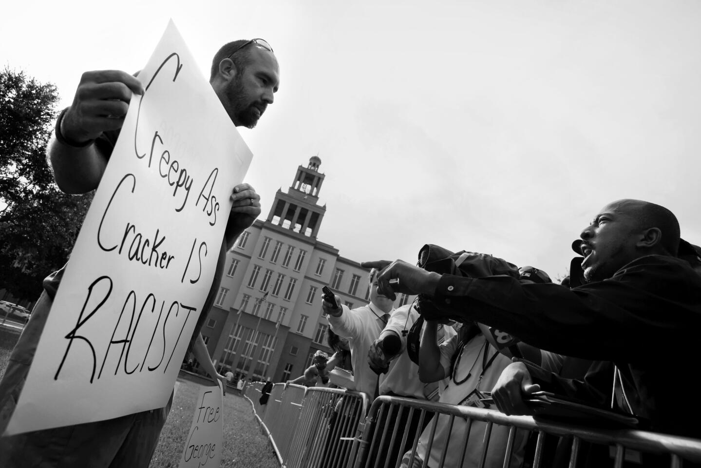 Adam Teasley holds a sign in support of George Zimmermanhe as he debates H. Alexander Duncan, right, on Friday, July 12, 2013 outside of the Seminole County Criminal Justice Center.