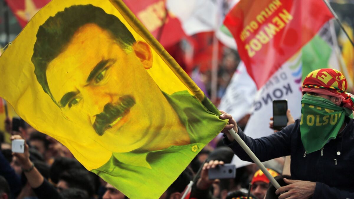 A youth holds a flag with the image of Abdullah Ocalan, the jailed leader of the rebel Kurdistan Workers Party, or PKK, in Istanbul, Turkey, in March 2018.