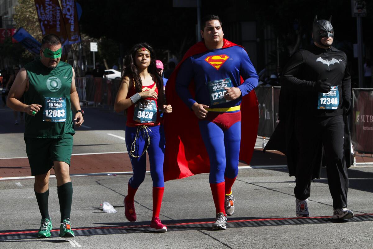 Superhero runners approach the finish line at the 2011 Rock 'n' Roll Los Angeles half marathon. The run takes place close to Halloween and many show up in costume.