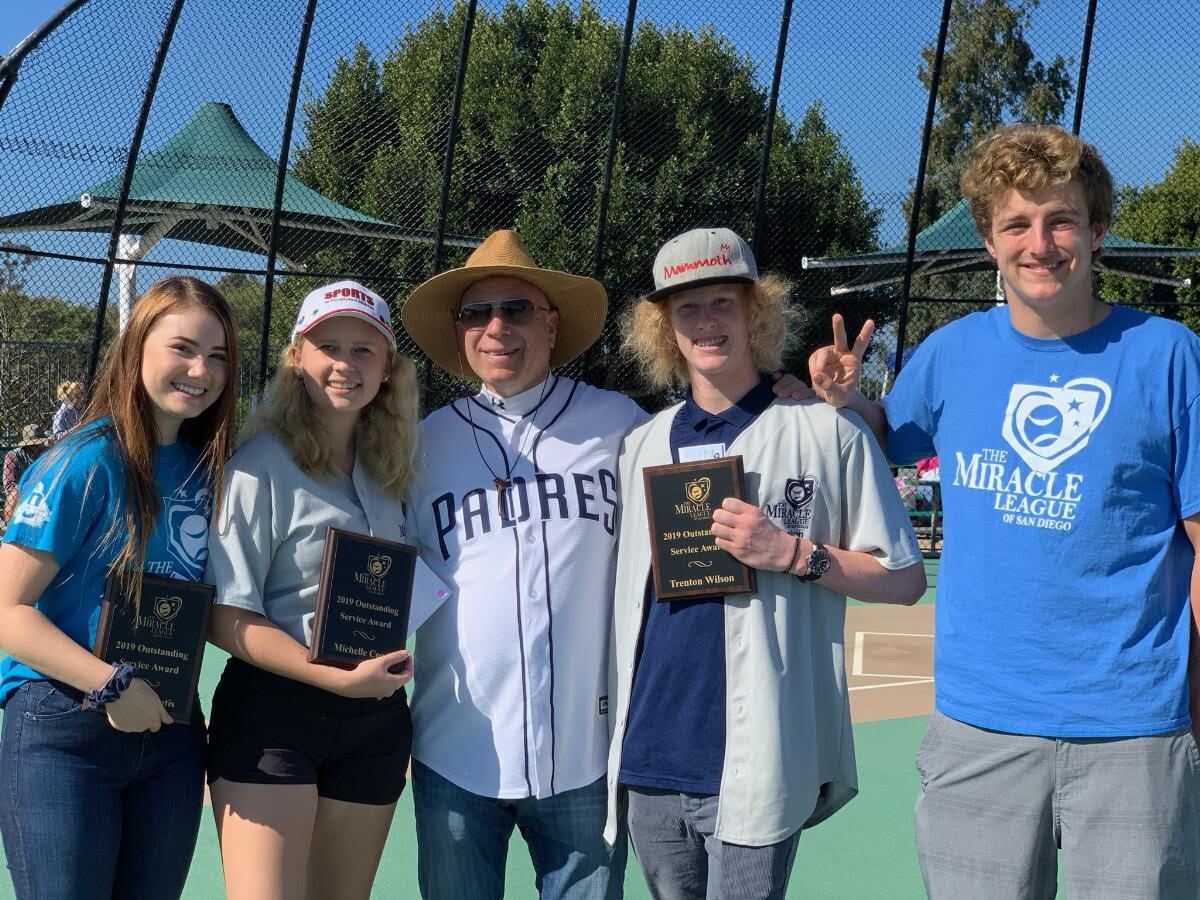 Four of this year's Outstanding Service Award recipients, Grace Laliotis, Michelle Coad, Trenton Wilson, and Trevor Hagen (left to right) receive their awards from Co-Founder Dan Engel.