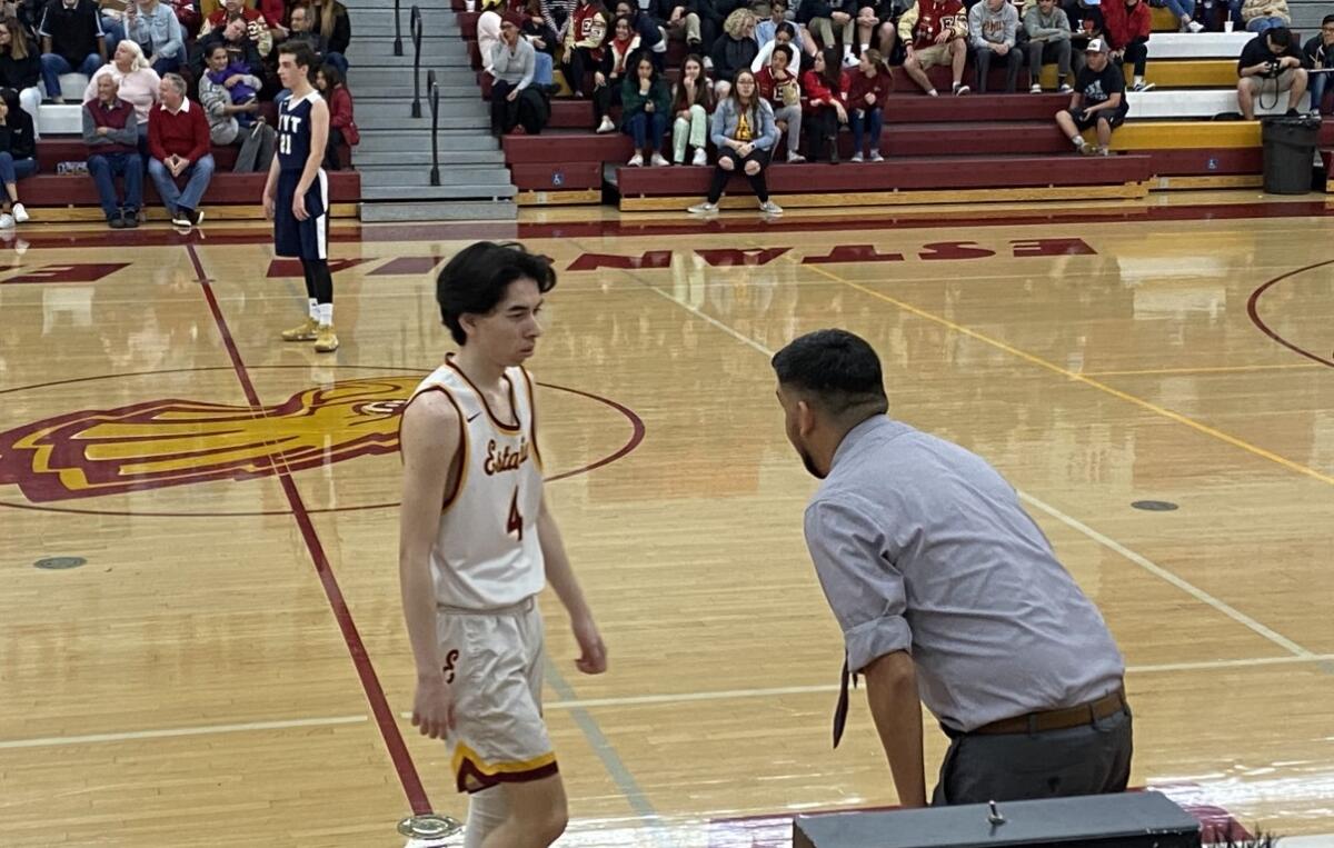 Estancia coach Xavier Castellano, right, talks with Ben Sparks in the first round of the CIF Southern Section Division 5AA playoffs against Tarbut V'Torah on Wednesday in Costa Mesa.