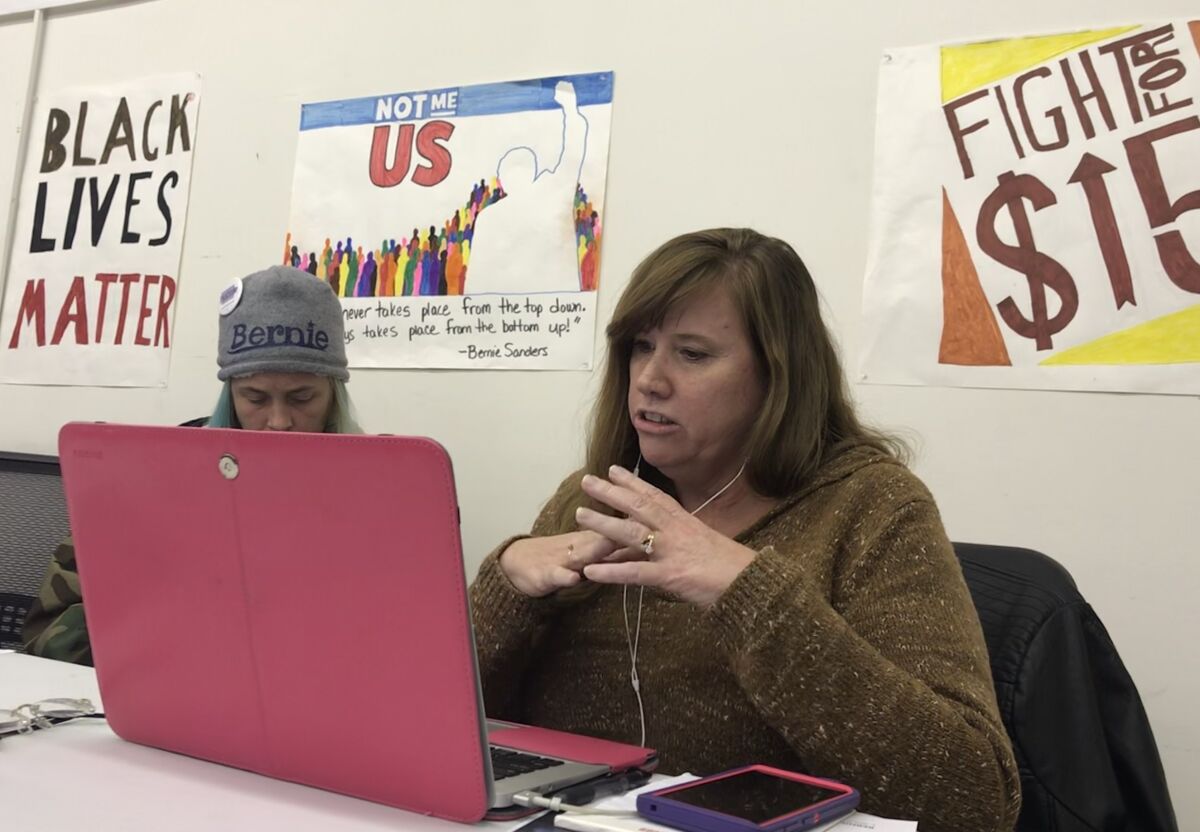 Sheila Campbell of Urbandale, Iowa, talks on the phone with a potential supporter of Sen. Bernie Sanders at a campaign office last week in Des Moines.