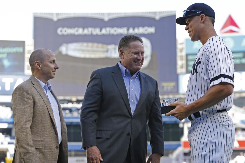 New York Yankees general manager Brian Cashman, left, and Yankees amateur scouting director Damon Oppenheimer, center, present New York Yankees Aaron Judge, right, with a crystal gavel before the Yankees final regular season baseball game in New York, Sunday, Oct. 1, 2017. (AP Photo/Kathy Willens)