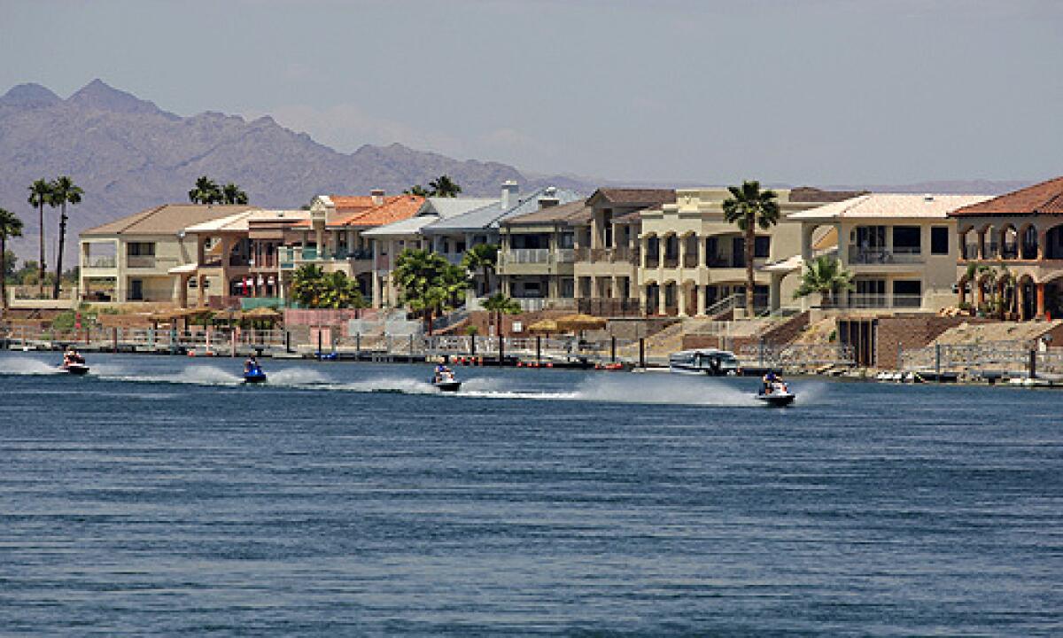 A view from Needles of jet skis passing in front of homes along the banks of the Colorado River in Arizona. Many Needles residents want their city to leave California and join Nevada.