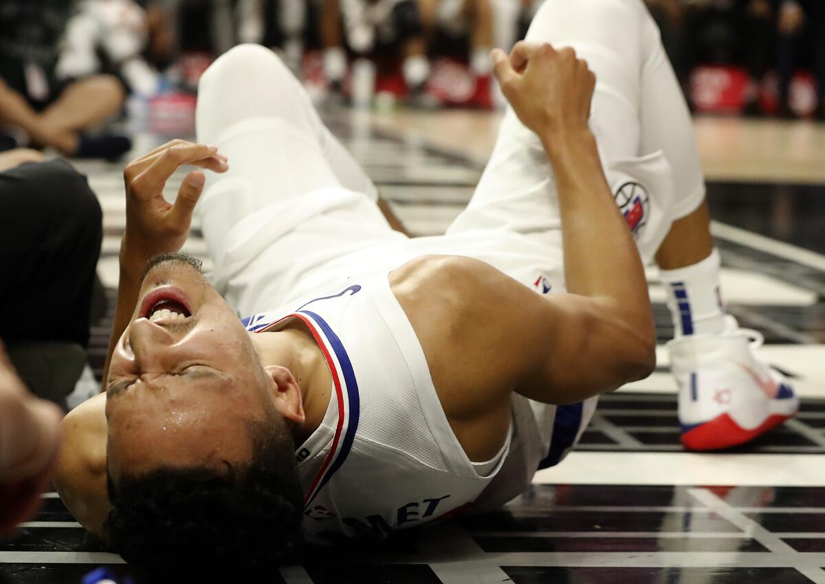 LOS ANGELES, CALIF. - NOV. 11, 2019. Clippers guard Landry Shamet writhes in pain aftewr hurting his knee against the Raptors in the fourth quarter at Staples Center in Los Angeles on Monday night, Nov. 11, 2019. (Luis Sinco/Los Angeles Times)