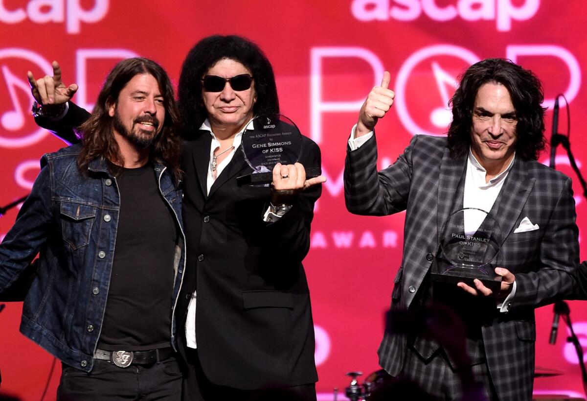 Dave Grohl, left, presents Gene Simmons and Paul Stanley of KISS the ASCAP Founders Award at the 32nd Annual ASCAP Pop Music Awards at the Loews Hollywood Hotel.