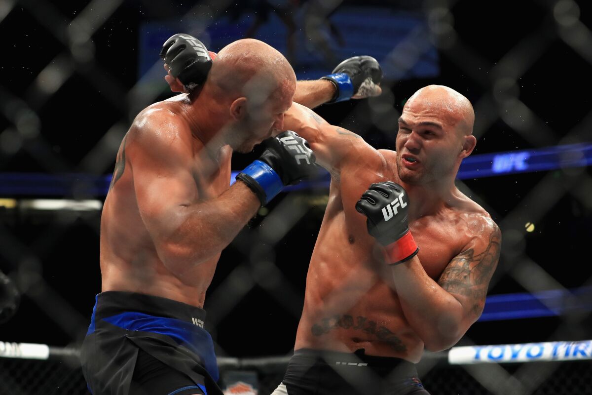 Donald Cerrone, left, and Robbie Lawler trade punches during their welterweight fight at UFC 214.