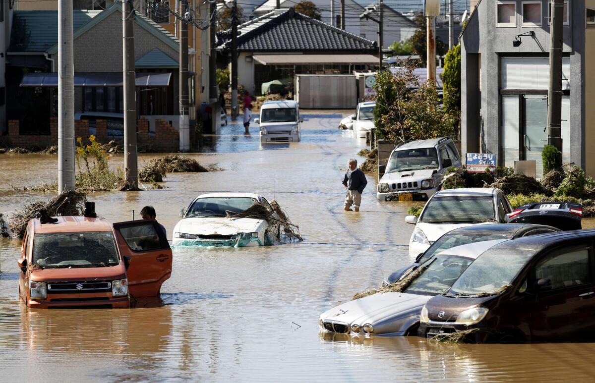 Vehicles sit in a flooded street in Sano, Japan, on Sunday after Typhoon Hagibis hit the Asian nation. Rescue efforts are underway after the powerful storm brought heavy rain and strong winds to a vast stretch of Japan, including Tokyo.