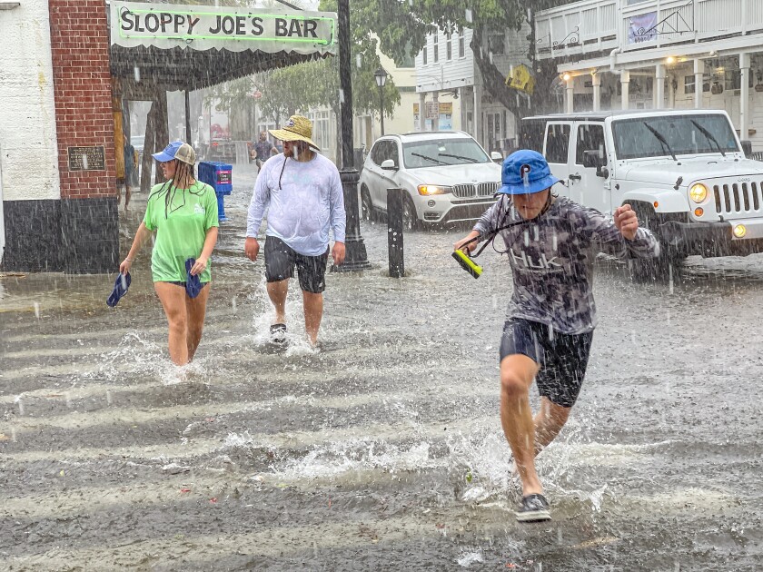 Pedestrians cross a flooded intersection.