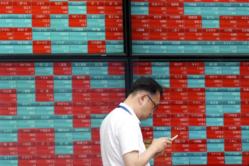 FILE - A person stands in front of an electronic stock board showing Japan's Nikkei index at a securities firm in Tokyo, on May 28, 2024. Asian shares traded mixed Wednesday, June 5, 2024, as investors weighed recent data highlighting a slowing U.S. economy that offers both upsides and downsides for Wall Street. (AP Photo/Eugene Hoshiko, File)