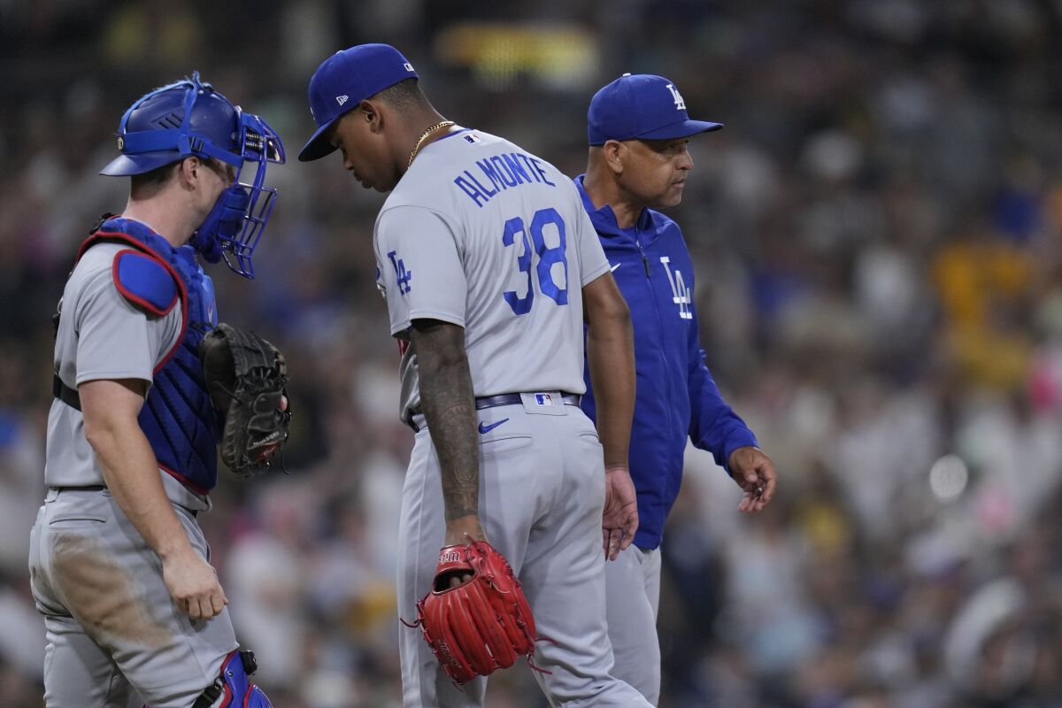 Los Angeles Dodgers manager Dave Roberts, right, takes the ball from relief pitcher Yency Almonte.