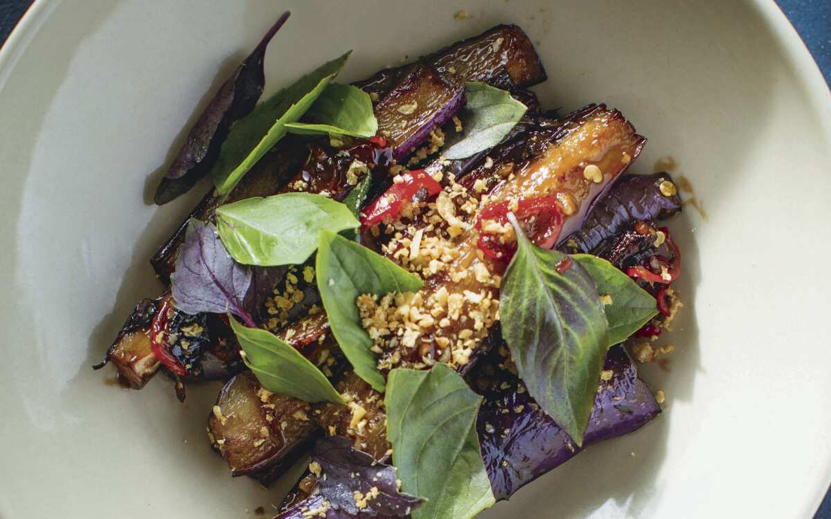 A closeup of an eggplant dish with garnishes.