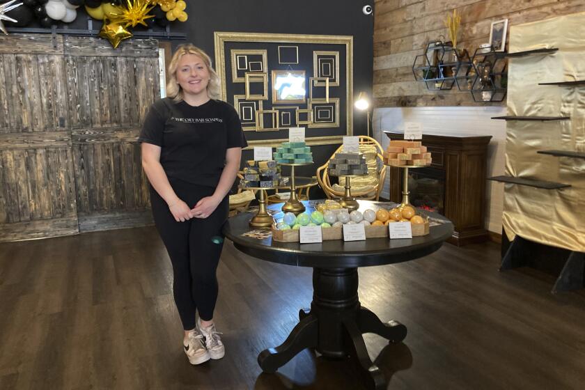 Kalee Hume stands alongside her handmade eclipse-themed soaps at her shop in downtown Waxahachie, Texas, on Saturday, April 6, 2024. Waxahachie will be in the path of totality for Monday's eclipse of the sun. (AP Photo/Marcia Dunn)