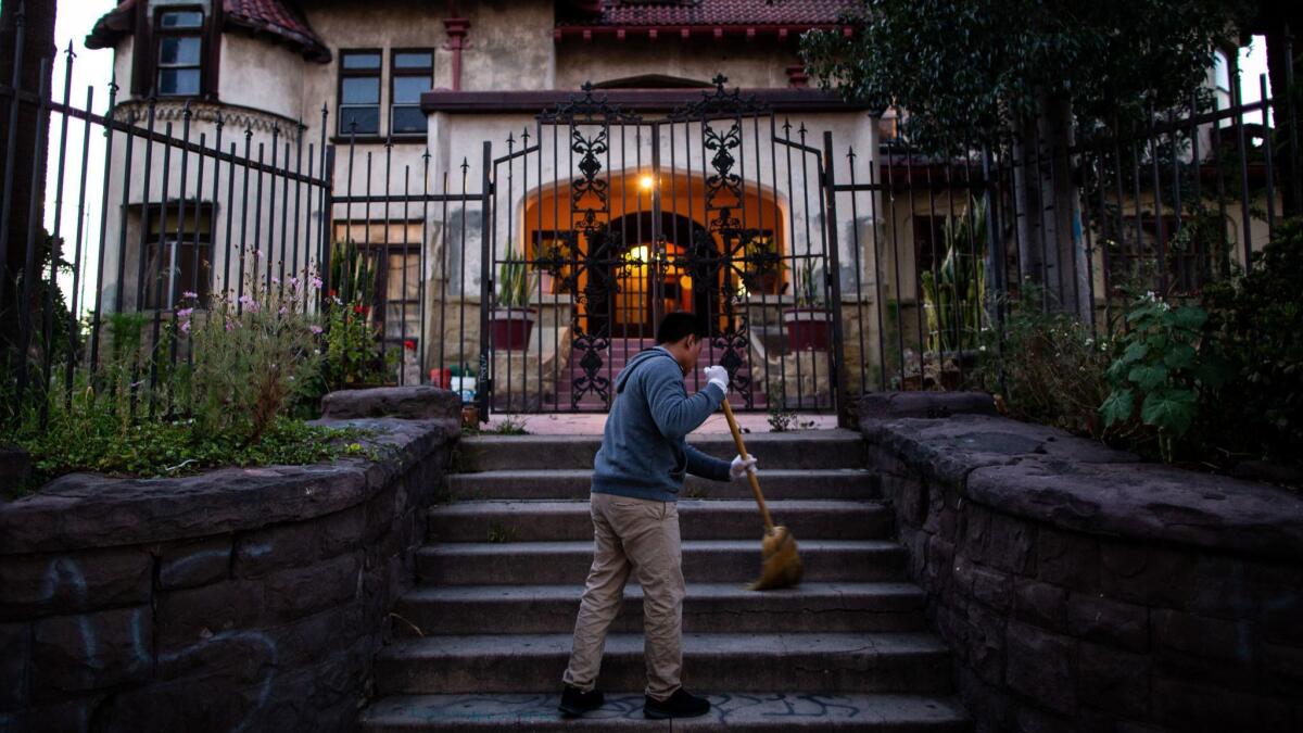Resident Hildner Coronado Atjun sweeps the front stairs of Casa Libre in May.