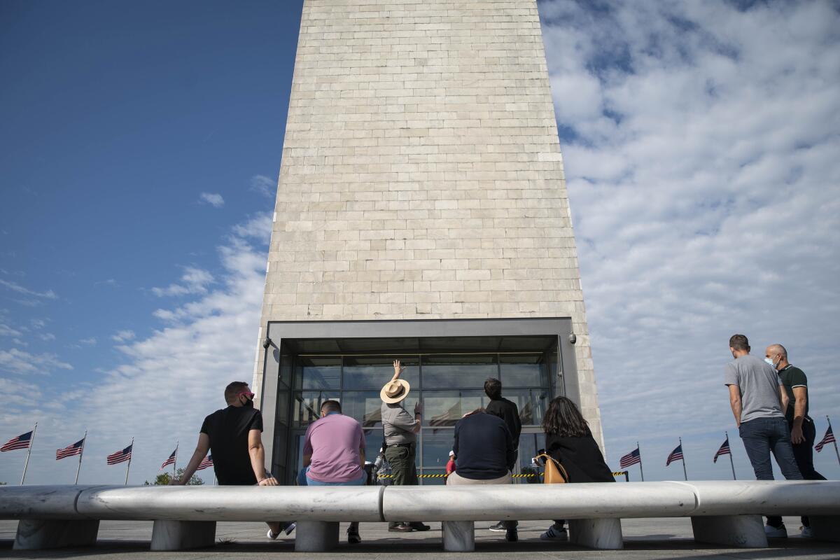 People returning to the Washington Monument, with a ranger pointing at the building.