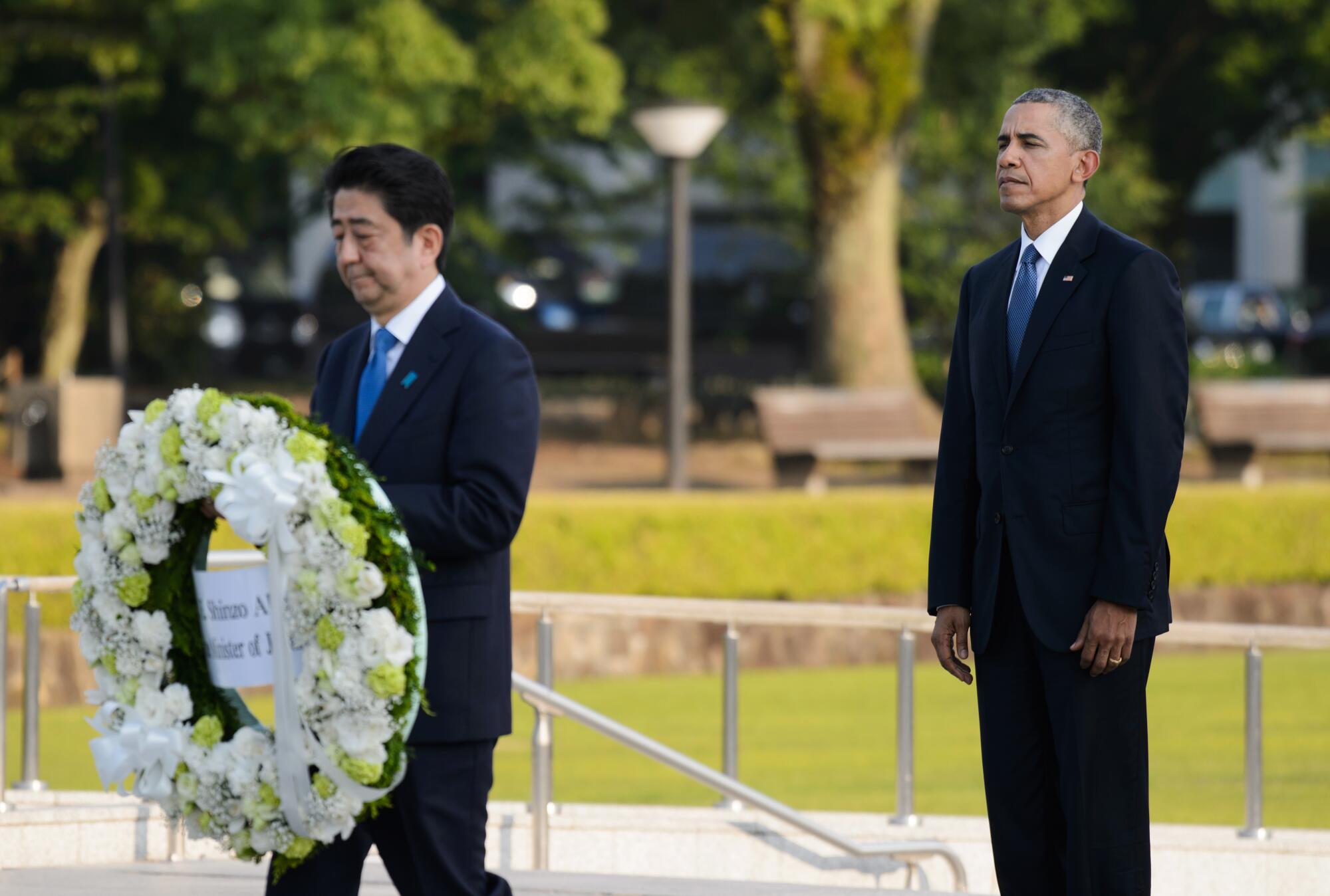President Obama looks on as Shinzo Abe, Japan's primer minister, carries a wreath 