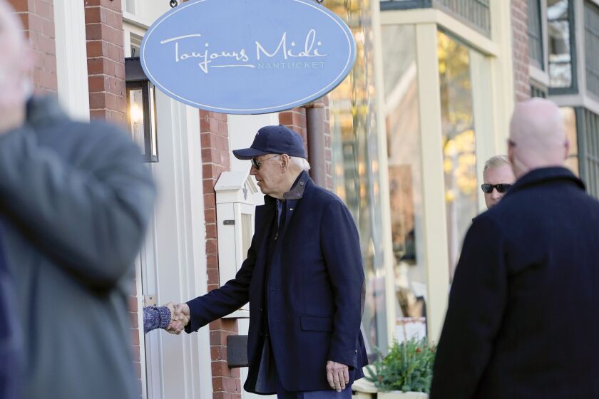 President Joe Biden shakes hands with a person as he visits shops with family members in Nantucket, Mass., Saturday, Nov. 26, 2022. (AP Photo/Susan Walsh)