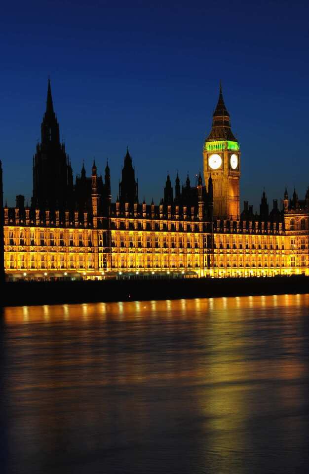 Lights burn bright around dusk at the Houses of Parliament, officially known as the Palace of Westminster, in London.