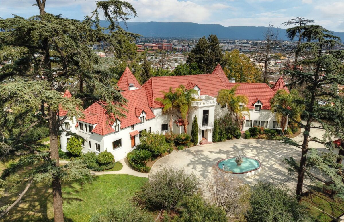Known as the Pyrenees Castle, the 1925 mansion sits behind walls and gates on a 2.6-acre knoll in Alhambra.