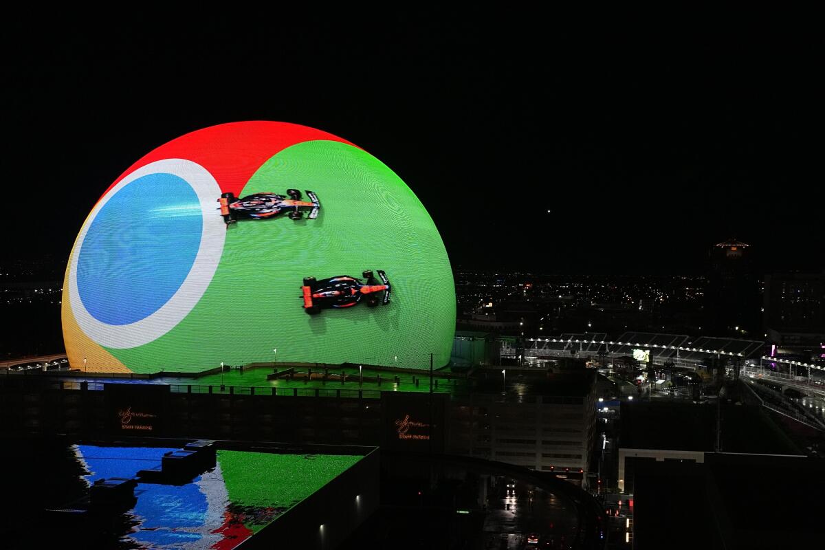 Formula One cars are displayed on the outside of the Sphere in Las Vegas on Wednesday night.