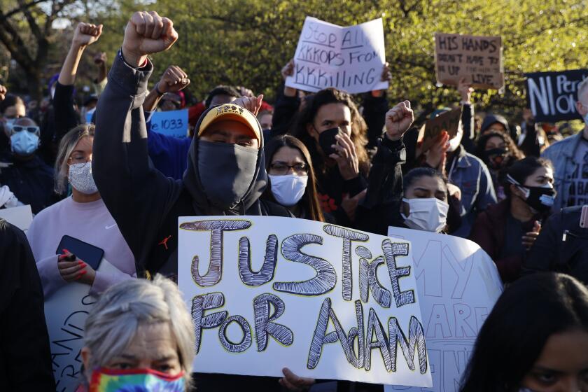 Demonstrators protest the shooting of 13-year-old Adam Toledo, Friday, April 16, 2021, in Logan Park in Chicago. Toledo was shot to death by an officer on March 29 in an alley west of the 2300 block of South Sawyer Avenue in Little Village on the Southwest Side. (AP Photo/Shafkat Anowar)