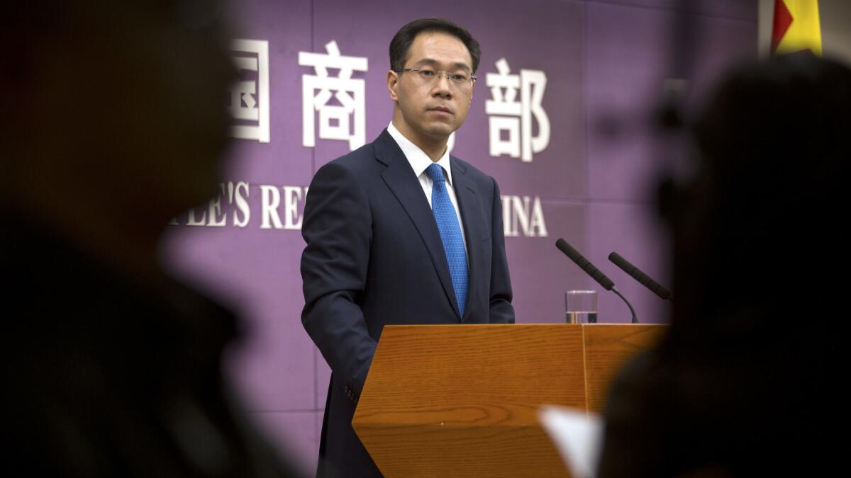 Chinese Ministry of Commerce spokesman Gao Feng speaks during a news conference in March. On Thursday, Feng said that Beijing "will not bow in the face of threats and blackmail" and will defend its interests.