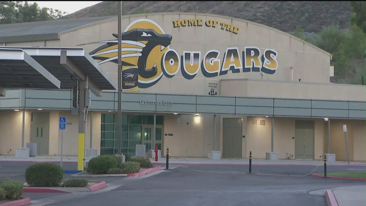 The exterior of a public school says "Home of the Cougars."